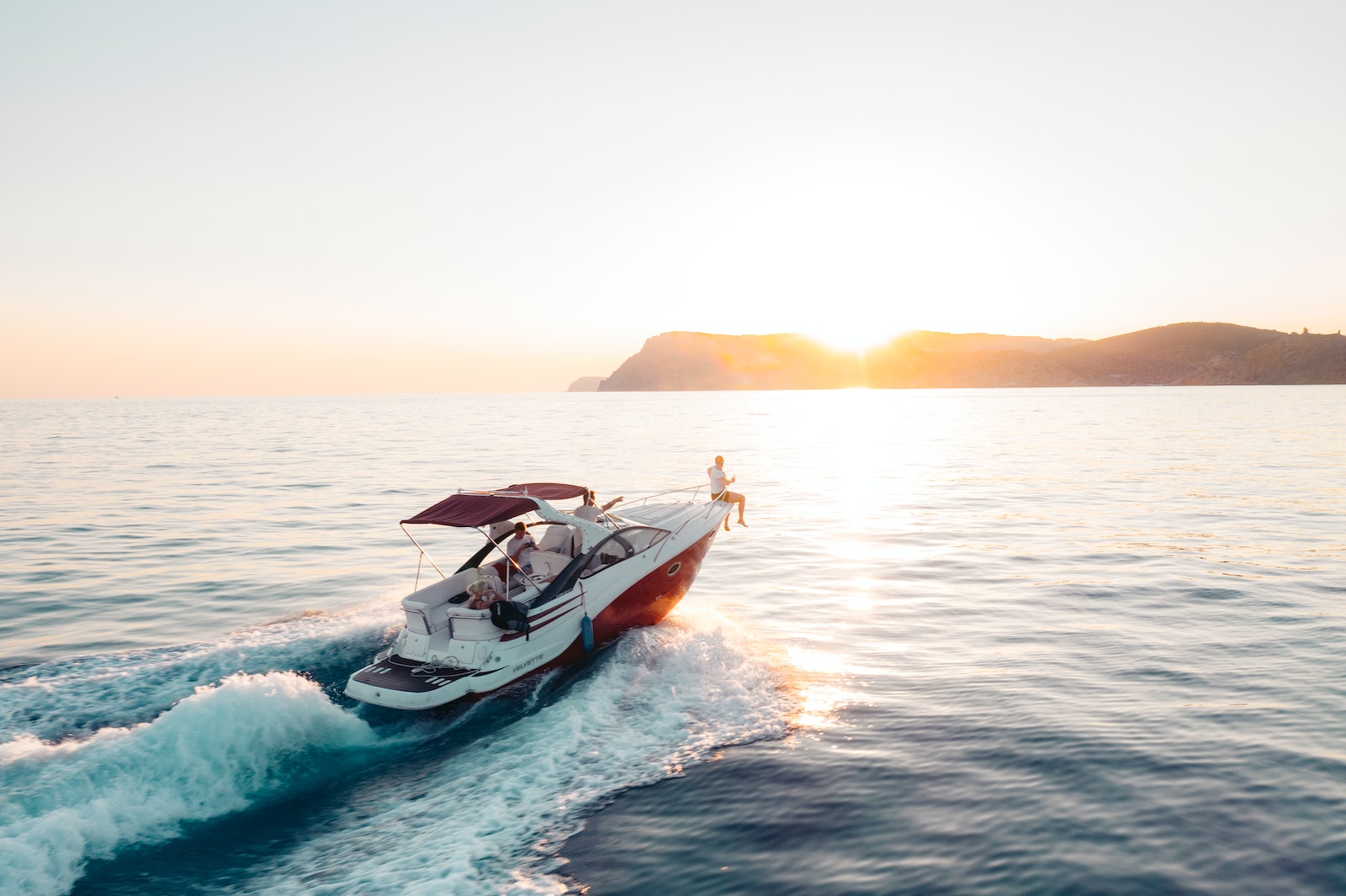 man riding on white and red boat on sea during daytime