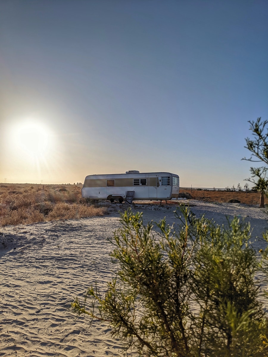 white rv trailer on brown field during daytime